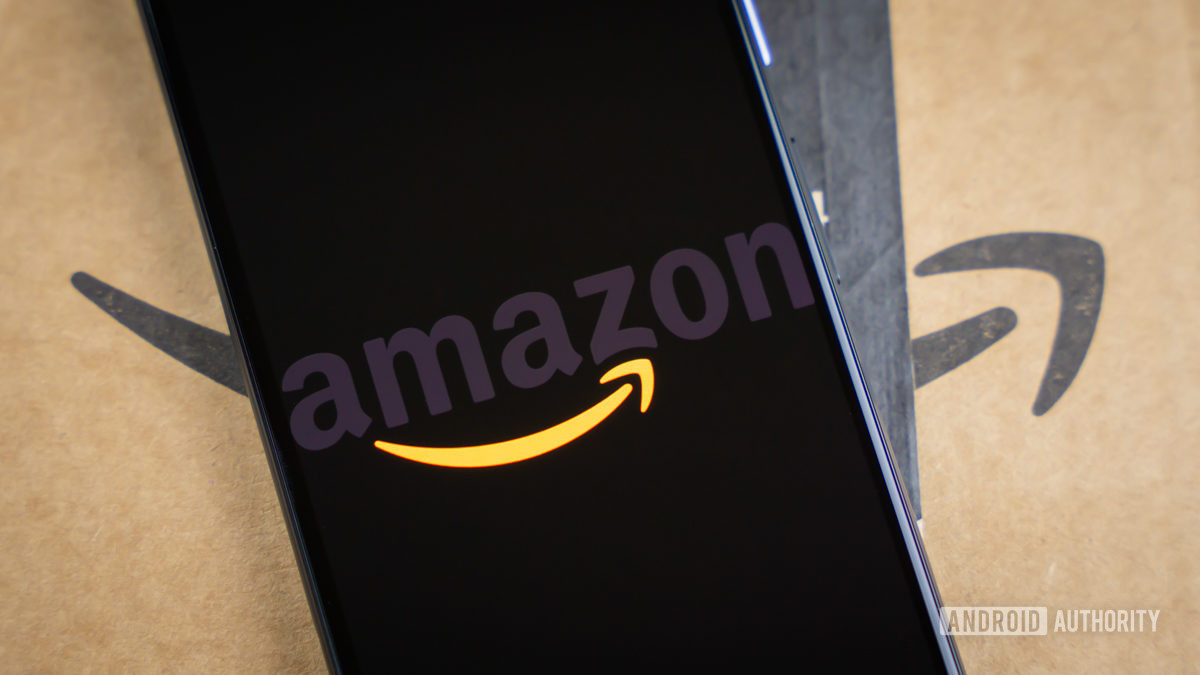Amazon logo on phone next to boxes stock photo 15