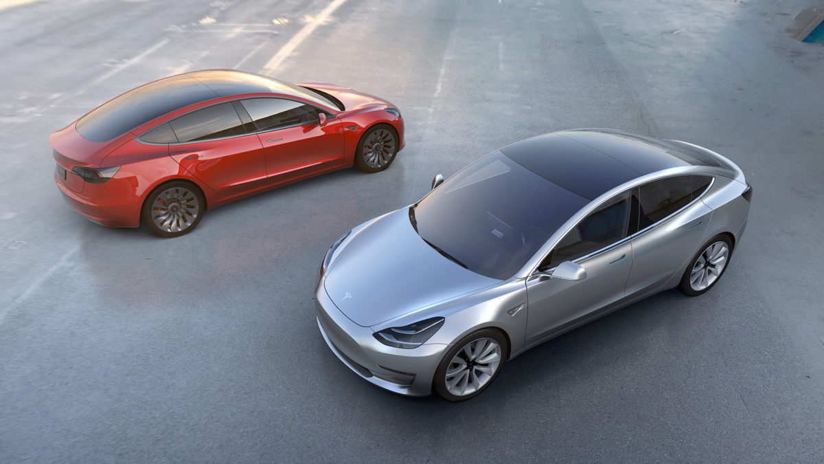 A pair of Tesla Model 3s in red and silver