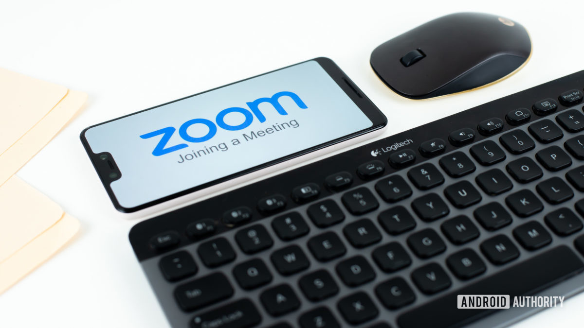 Zoom Meetings on smartphone next to office equipment stock 3
